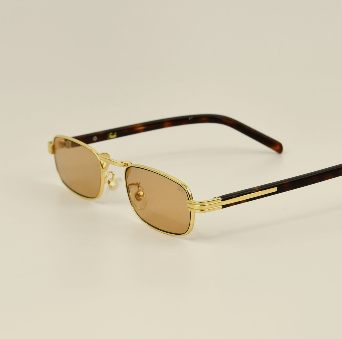 TUDI Axel gold-frame sunglasses with amber lenses, three-quarter view