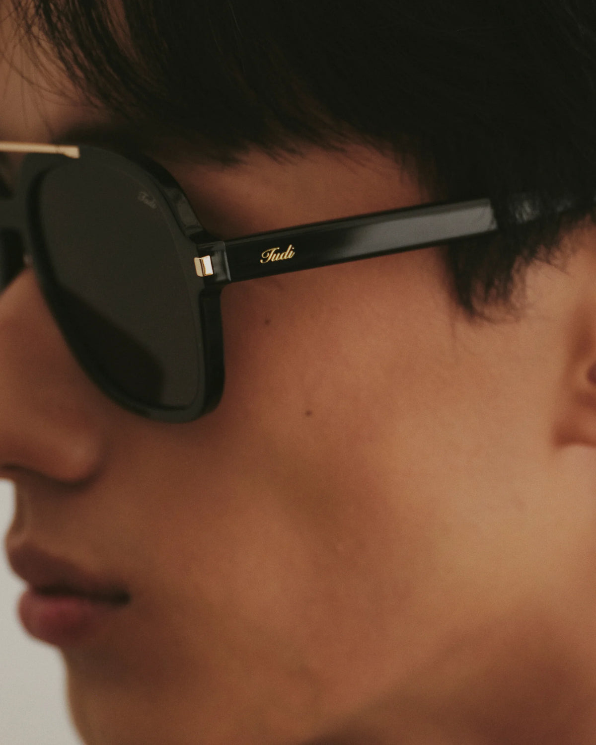 TUDI Blake eyewear, worn detail, black frame; dark lenses
