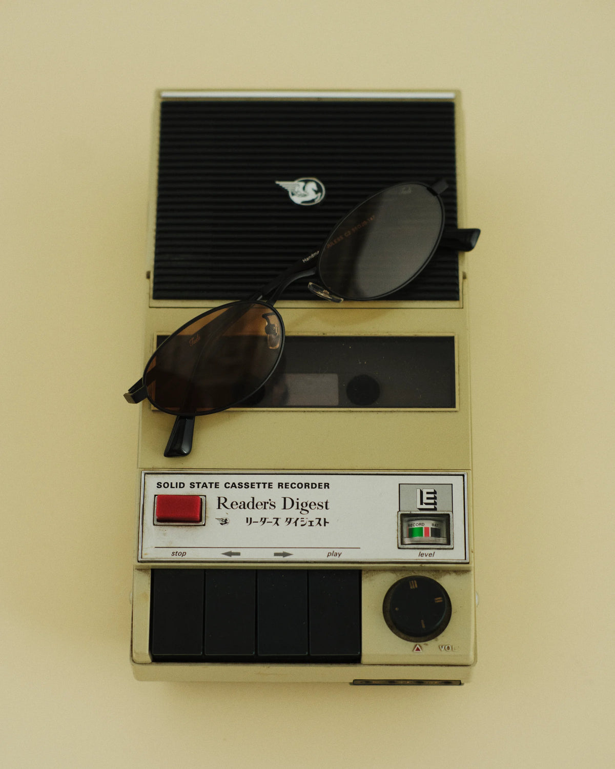 TUDI Juless eyewear, styled still life, black metal; dark and amber lenses