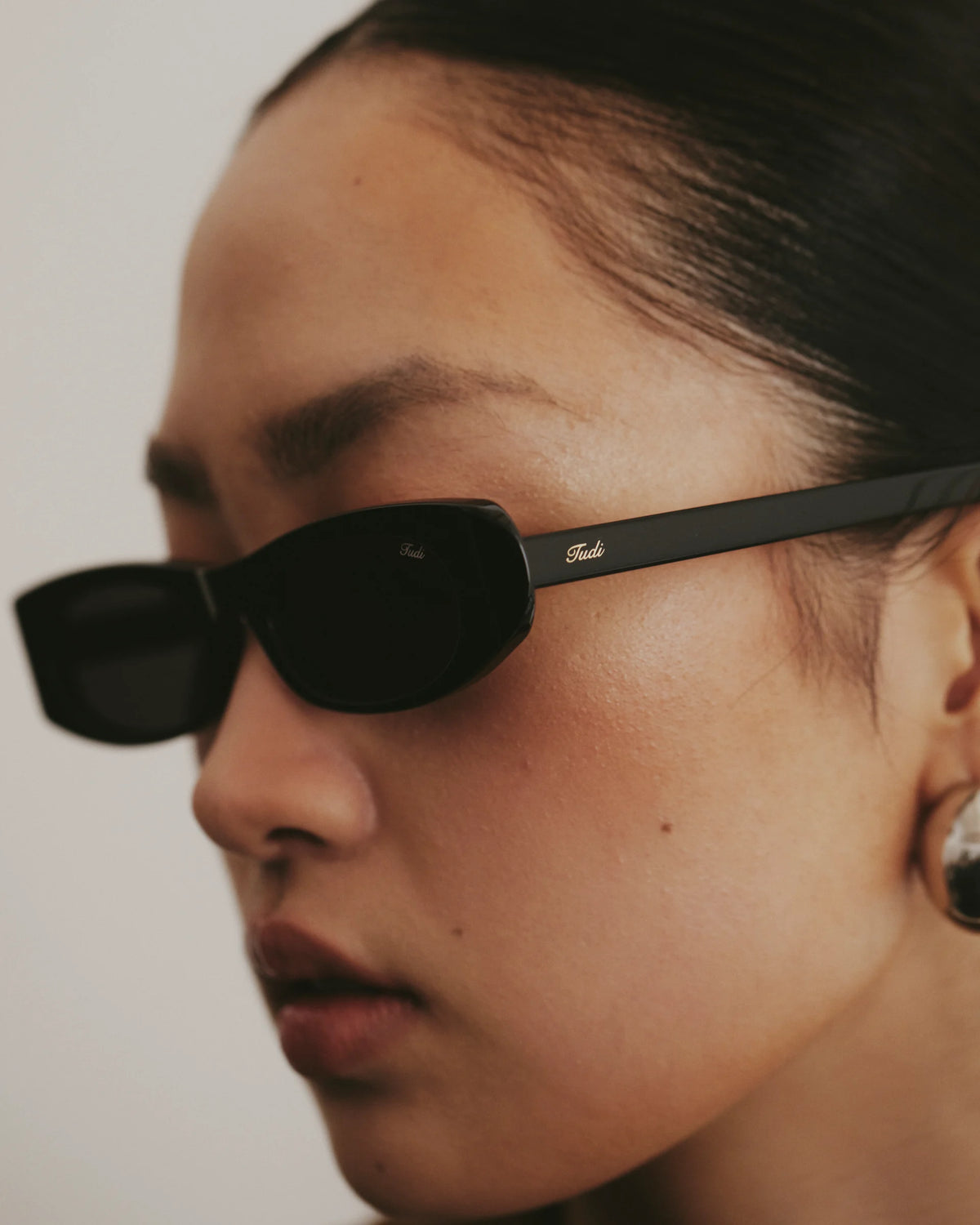 TUDI Kai eyewear, lifestyle, black frame; dark lenses