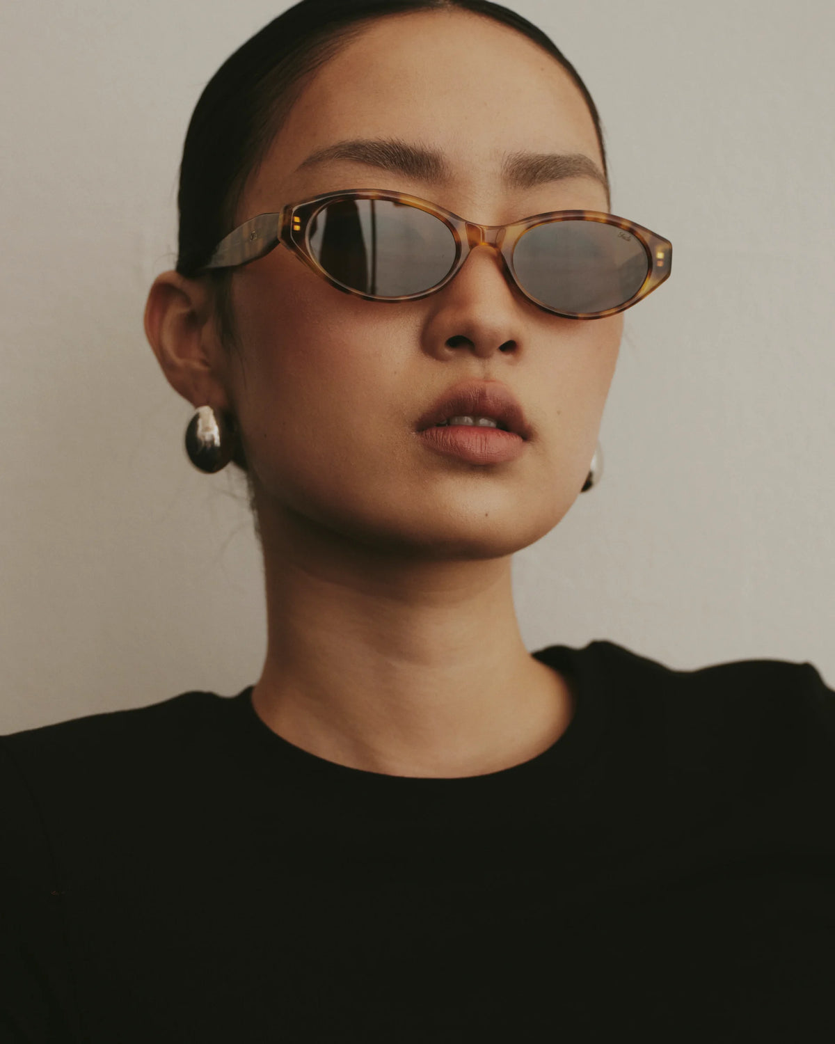 TUDI Mabel eyewear, lifestyle, amber havana frame; dark lenses