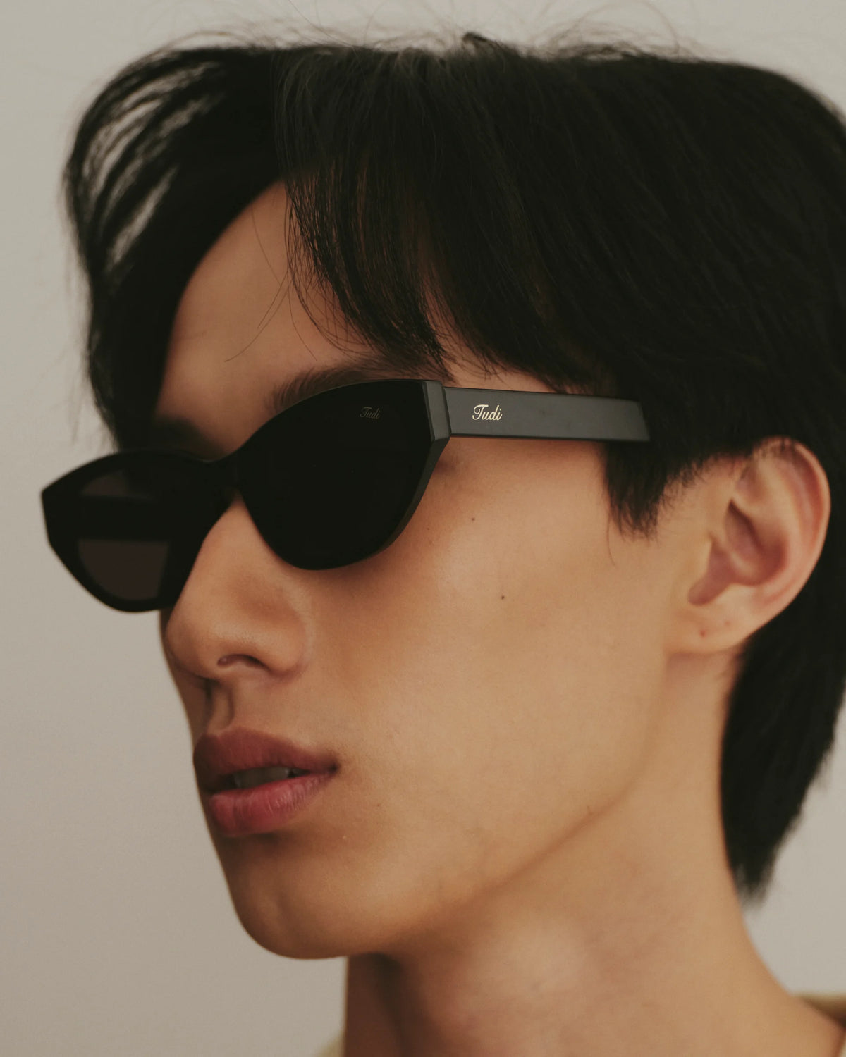 TUDI Molly eyewear, lifestyle, black front; olive-green temples; dark lenses