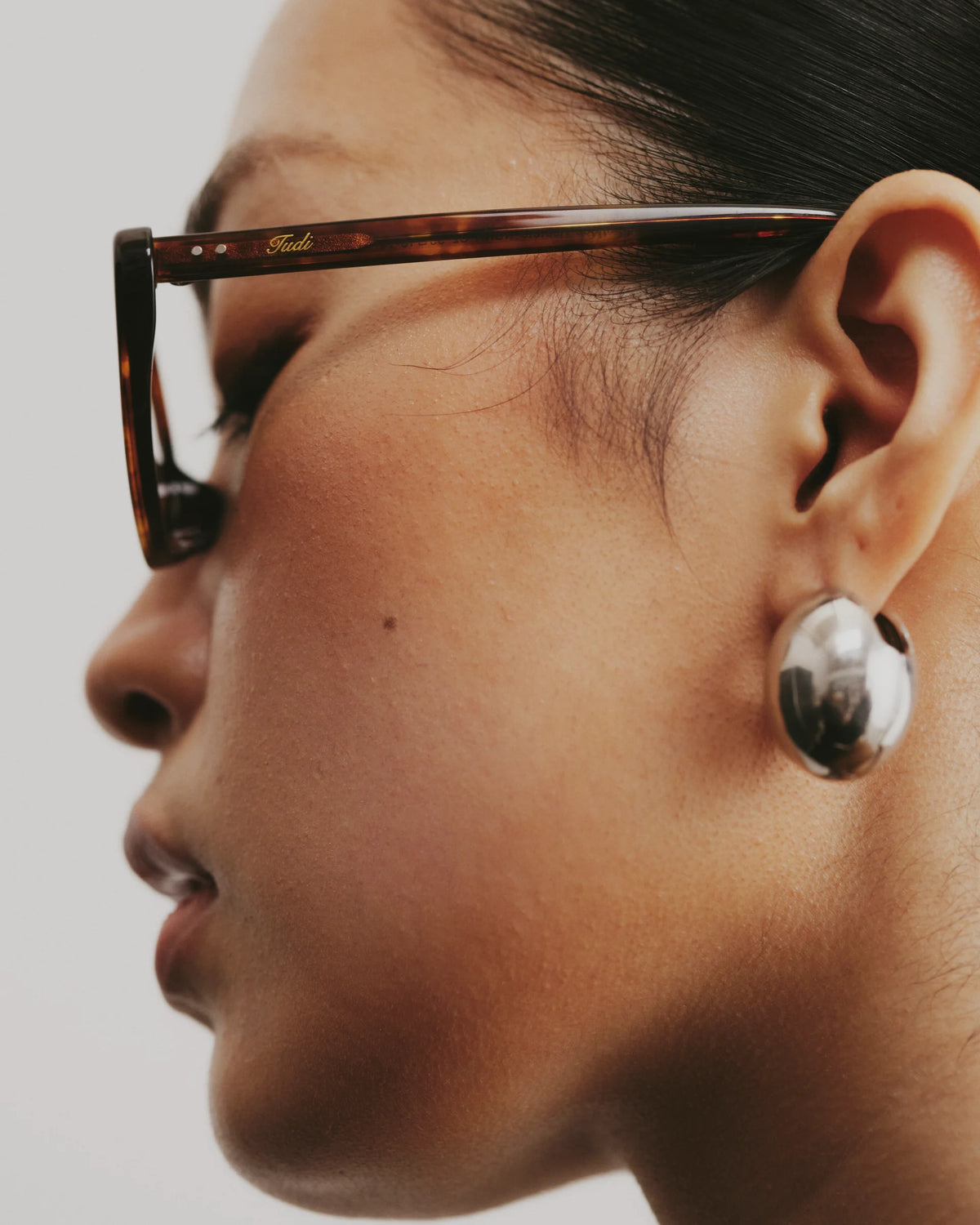 TUDI Nuna Brown tortoiseshell frame; dark lenses eyewear, worn detail